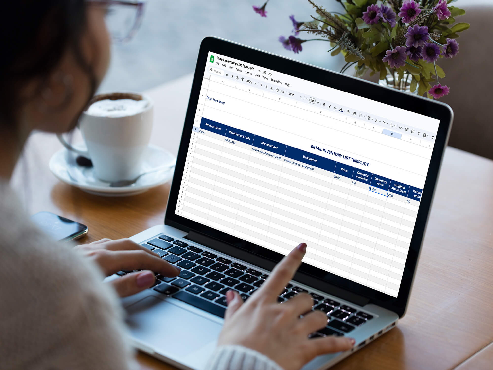 A woman works on a retail inventory list template next to a cup of coffee.